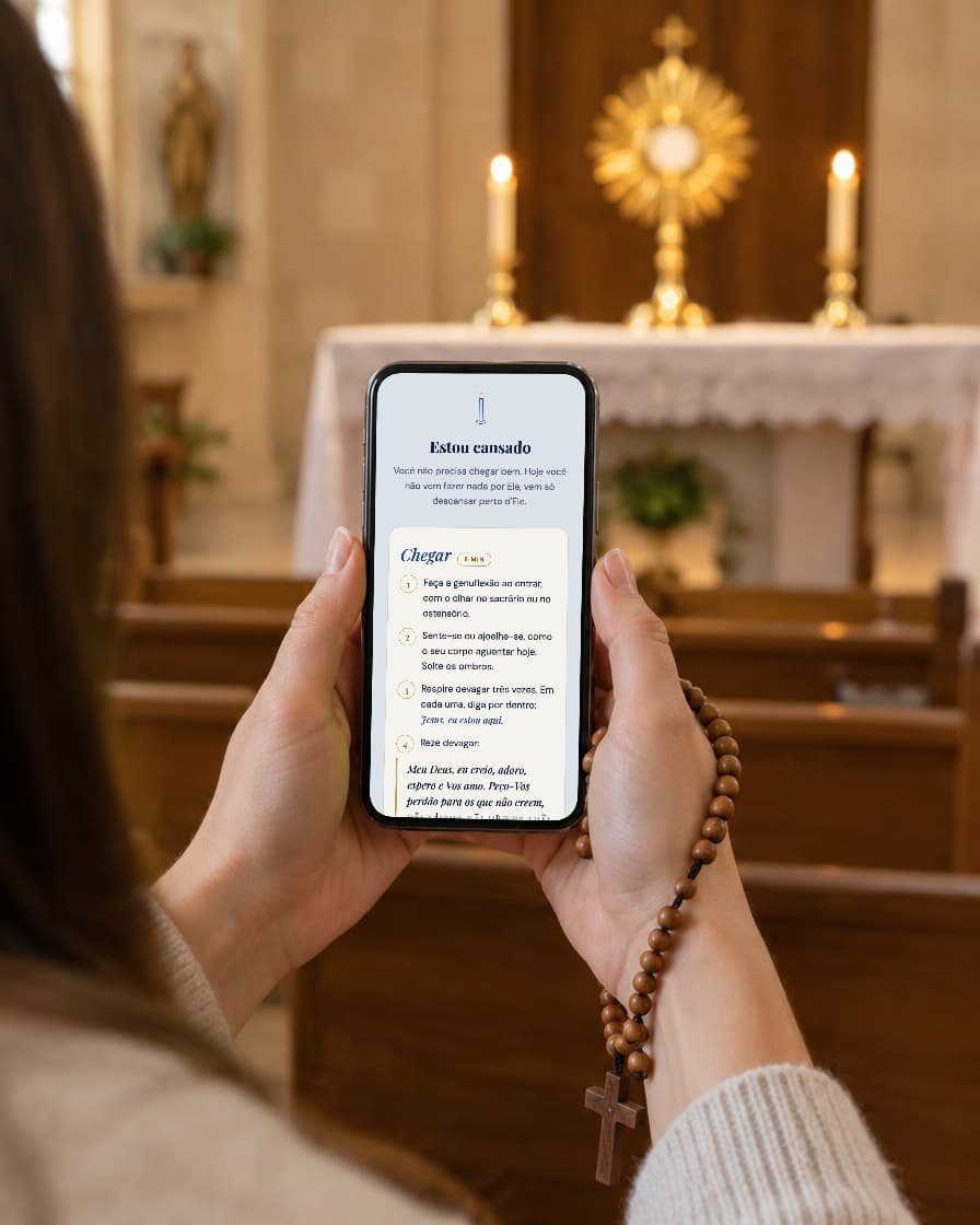 Mãos segurando o celular com o roteiro aberto, diante do Santíssimo exposto na capela